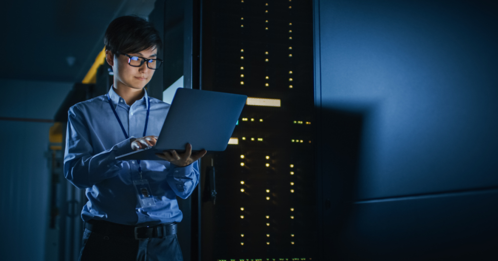 cybersecurity trend monitoring a woman standing next to servers.