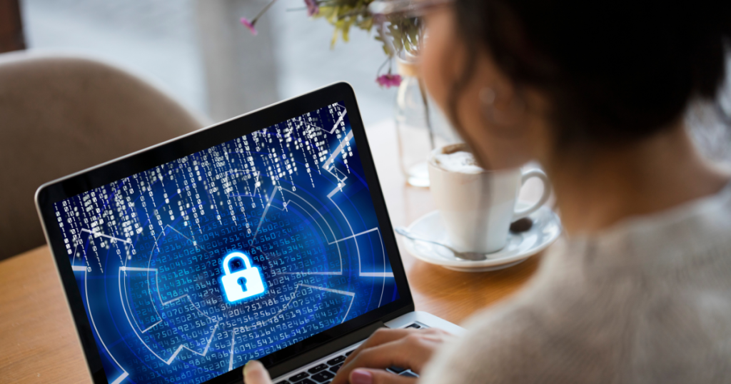 Woman sitting at a laptop monitoring cybersecurity trends for 2025