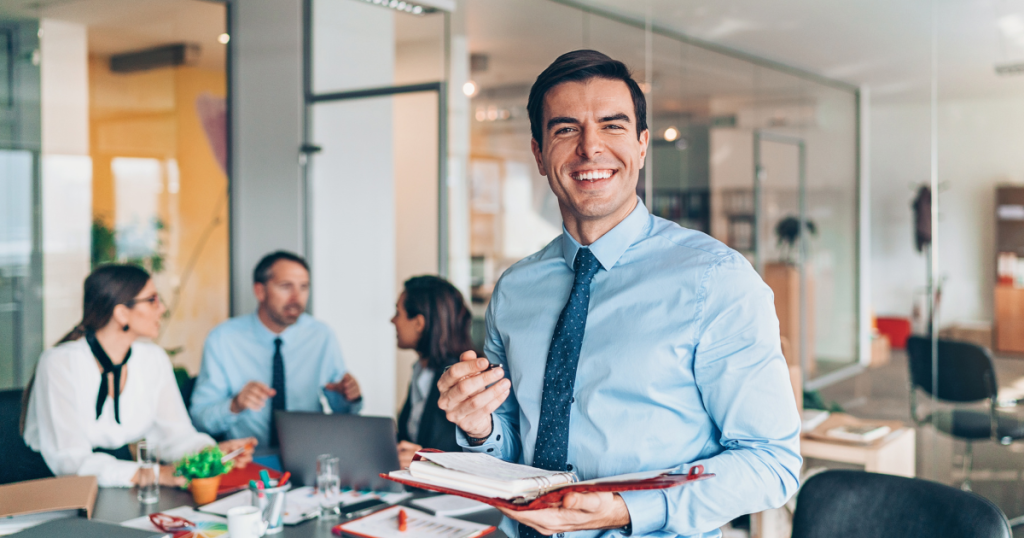 man standing in a meeting with his planner getting ready to plan a business optimization.